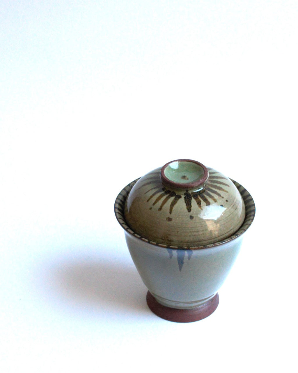 Lidded bowl in wam green with iron strokes