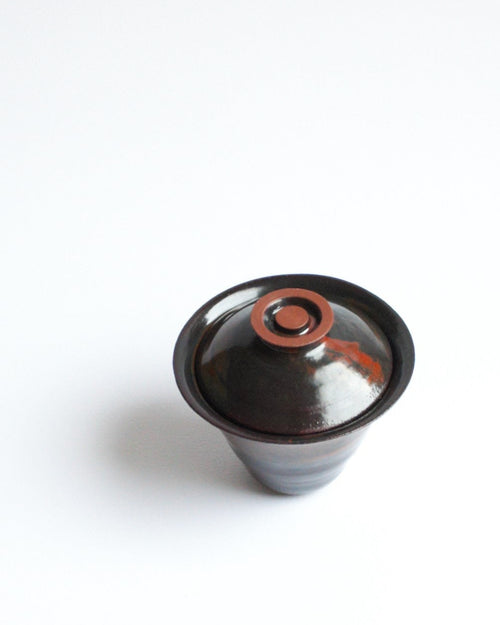 Ceramic cup with a lid on a white background